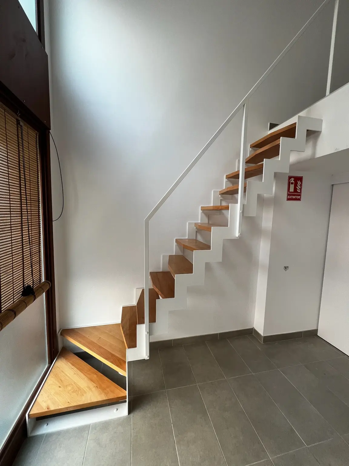 Escalera MANI Z blanca con zancas dentadas, peldaños de madera y barandilla metálica